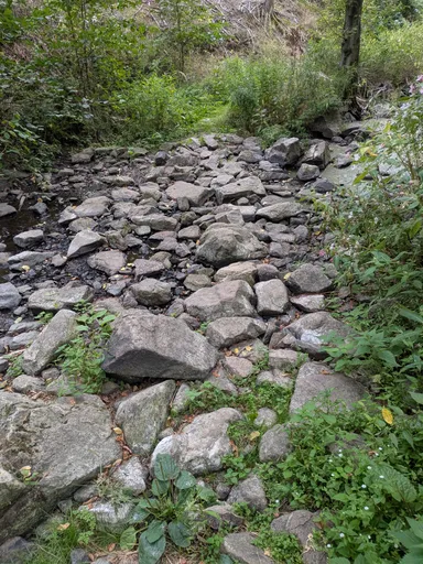 Široké suché kamenité koryto potoka v celé šíři