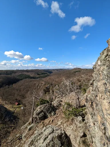 Skalnaté útesy u Levnova nad zimním údolím Oslavy pod modrou oblohou.