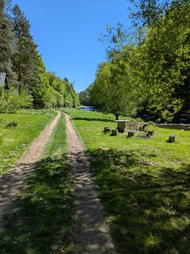 Polní cesta podél řeky Oslavy s posezením u kamenného stolu na louce.
