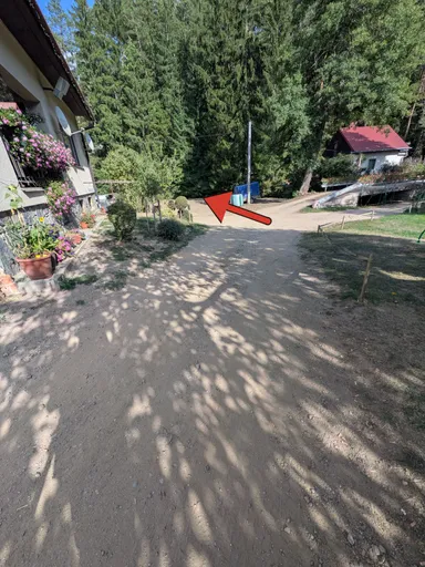 Rozcestí u chalupy pod sloupem; červená šipka ukazuje doleva, kudy dál