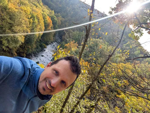 Selfie poutníka na skále nad kaňonem Oslavy, v pozadí řeka a podzimní stromy.