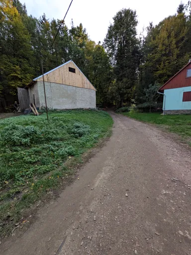 Polní cesta mezi chatami v údolí Oslavy, vlevo nová dřevěná kůlna.